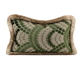 May include: A rectangular decorative pillow with a green and gray pattern, framed by a tan fringe. The pillow's design features a repeating pattern of overlapping shapes, creating a textured appearance. The pillow is designed for home decor.