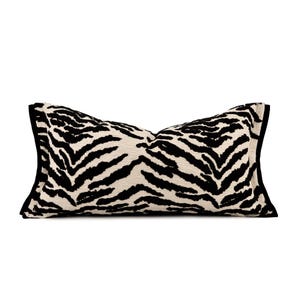 May include: A rectangular decorative pillow with a zebra print pattern. The pillow features black stripes on a cream-colored background, with a black border. This accent pillow is designed for home decor.