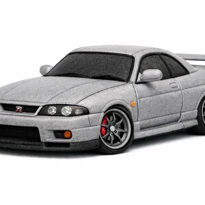 May include: A grey sports car with a rear spoiler, black front bumper, and red brake calipers. The car has a detailed design with visible headlights, side mirrors, and a prominent front grille. The car is set against a white background.