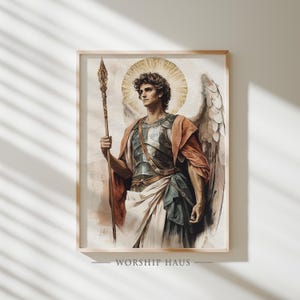 May include: Framed watercolor print of an angel with a golden halo, holding a spear. The angel wears armor, a red cloak, and has large feathered wings. The artwork is labeled "WORSHIP HAUS" at the bottom.