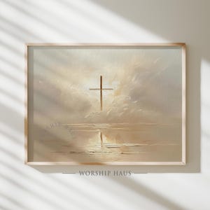 May include: A framed print featuring a cross above a body of water, set against a cloudy, light-filled sky. The artwork has a soft, muted color palette with the text "WORSHIP HAUS" at the bottom.