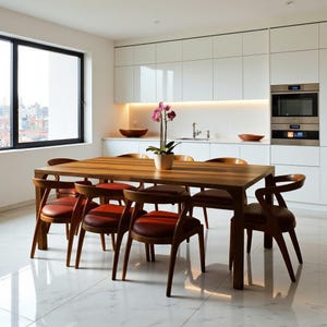 May include: A modern dining room set featuring a rectangular wooden table and six chairs. The chairs have reddish-brown leather seats and curved wooden backs. A potted orchid sits on the table. The room has white cabinets and a large window.