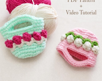 May include: A mint green crocheted basket with pink floral accents and a pink crocheted hat with white lily of the valley flowers, accompanied by balls of pink and cream yarn, with the text PDF Pattern + Video Tutorial visible.