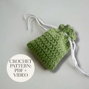 May include: A handmade green crochet pouch with white drawstring closure. The pouch is a soft, textured fabric. Text on the image reads "CROCHET PATTERN: PDF + VIDEO".