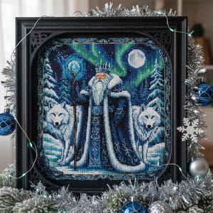 May include: Framed cross-stitch art depicting a winter scene with a regal figure, two white wolves, and an aurora borealis backdrop. The artwork is in a black frame and decorated with Christmas ornaments and garland.