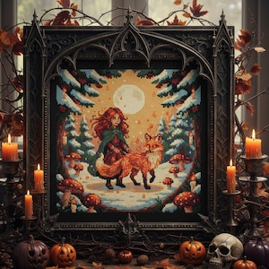 May include: A framed cross-stitch artwork depicts a girl with red hair and a fox in a snowy forest scene under a full moon. The frame is ornate and dark, surrounded by candles, pumpkins, and autumn foliage, creating a seasonal, gothic aesthetic.