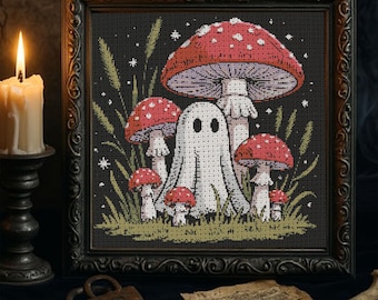 Pode incluir: Arte de ponto cruz em uma moldura preta com uma cena fantasiosa com cogumelos vermelhos e brancos manchados, um fantasma amigável e capim alto. A obra de arte tem uma estética sombria e gótica, com uma vela acesa e um cadeado antigo em primeiro plano.