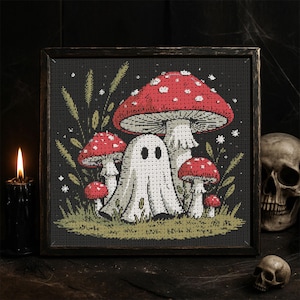 May include: Cross-stitch art in a dark wooden frame. The image features a white ghost with a friendly expression, surrounded by red and white spotted mushrooms and green foliage against a black background. A spooky Halloween theme.