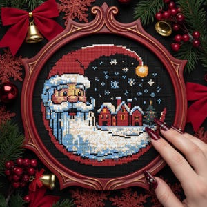 May include: A cross-stitch Christmas ornament featuring Santa Claus with a snowy village scene, framed in a red oval. The design includes a red hat, a white beard, and a black night sky with snowflakes. The frame is surrounded by Christmas decorations.
