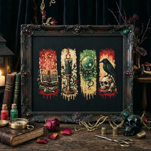 May include: Framed cross-stitch art featuring four vertical panels with mystical themes. Panels include an open book, a candle, a crystal ball, and a raven on a skull. The frame is dark with red and green accents, set against a dark background.