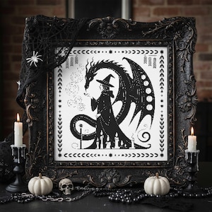 May include: Ornate black framed cross-stitch art depicting a witch and dragon in black and white. The witch wears a hat and cloak, holding a wand. The dragon has large wings. The frame is decorated with candles, pumpkins, and a skull.