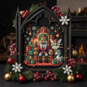 Op de afbeelding: Een ingelijste kruissteek met een kersttafereel met een notenkrakerkoning, een fee en een eenhoorn. Het kunstwerk is omgeven door feestelijke decoraties, waaronder ornamenten, sneeuwvlokken en groen. Het frame is donker en het kleurenschema is levendig.