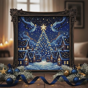 May include: A framed cross-stitch depicting a winter village scene with a Christmas tree and angels under a starry night sky. The artwork is in a dark wooden frame, with blue and gold ornaments and ribbon on a wooden surface.
