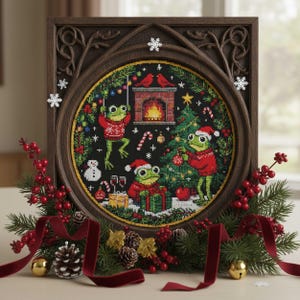 May include: A framed cross-stitch featuring a Christmas scene with three frogs wearing Santa hats and sweaters. The frogs are decorating a Christmas tree and opening presents. The frame is dark brown, and the scene is surrounded by festive greenery and red ribbon.