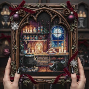 Puede incluir: Un bordado enmarcado que representa una escena de cocina de brujas con una luna llena en la ventana. El marco de madera está adornado con cinta de terciopelo roja, piñas y adornos. La escena incluye estantes con tarros, un caldero y velas encendidas.