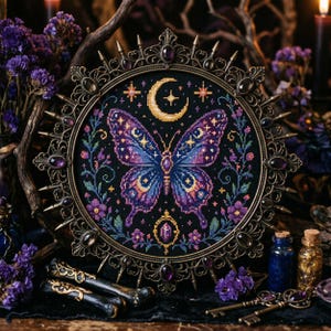 May include: A framed cross-stitch featuring a butterfly with purple and blue wings, a crescent moon, and stars. The artwork is set against a black background and surrounded by a decorative bronze frame with purple accents. The overall theme is mystical.