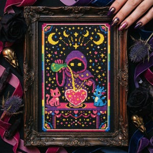 May include: Cross-stitch art in a dark ornate frame. The artwork features a hooded figure pouring liquid into a heart-shaped vessel, with a pink cat and blue creature. The background is black with stars and moons, and the border is rainbow.