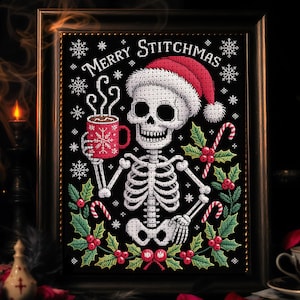 May include: Framed cross-stitch artwork depicting a skeleton in a Santa hat, holding a red mug with a snowflake design. The words "Merry Stitchmas" are stitched above. Holly, berries, and candy canes adorn the image, creating a festive, gothic theme. The frame is dark.