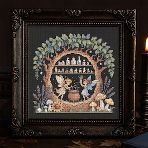 Pode incluir: Obra de arte em ponto cruz num quadro escuro e ornamentado. A obra retrata uma cena fantástica com fadas, cogumelos e uma árvore com prateleiras de frascos de poções. A paleta de cores inclui verdes, castanhos e azuis.