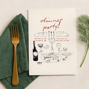 May include: An invitation card with the words "dinner party!" in red script. The card features a black and white illustration of a dinner setting, including food and wine. A gold fork rests on a green napkin.