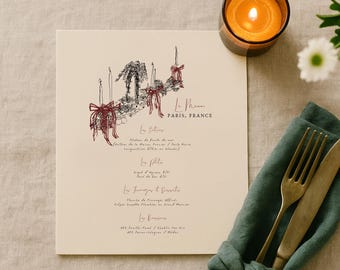 Op de afbeelding: Een crèmekleurige menukaart met een zwart-rode inktillustratie van kaarsen met strikken, getiteld Le Menus PARIS, FRANCE, met secties voor Les Entrees, Les Plats, Les Fromages et Desserts en Les Boissons, vergezeld door een vork en een mes.