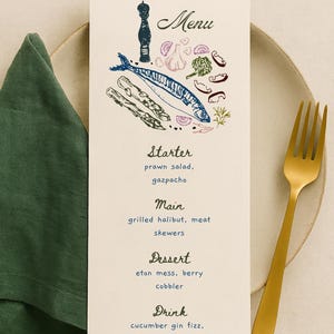 May include: A menu card with a seafood illustration, featuring a fish, vegetables, and the word "Menu" at the top. The menu lists starter, main, dessert, and drink options. A gold fork and green napkin are on a beige plate.