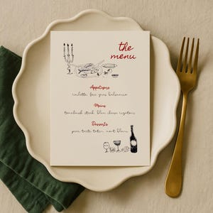 May include: A menu card with the words "the menu" in red script. The menu features appetizers, mains, and desserts, with illustrations of food and wine glasses. The card rests on a white scalloped plate with a gold fork.
