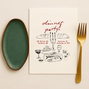 May include: An oval, dark green ceramic plate with a brown rim sits next to a cream-colored invitation. The invitation features a hand-drawn illustration of a dinner setting with the words "dinner party!" in red script. A gold fork is on the right.