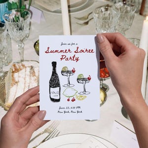 May include: A white invitation card with the text "Join us for a Summer Soiree Party" in red and black. The card features illustrations of a wine bottle, cocktails, and fruit. The event details include the date, time, and location: June 22, 5:00 PM, New York, New York.