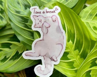 May include: A sticker featuring a light purple cat lying on its back with the text "Take a break" in black script. The sticker is set against a backdrop of green leaves with darker green patterns.