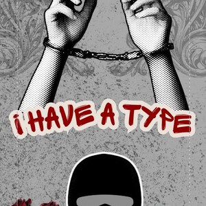 May include: Graphic design featuring hands in handcuffs, the text "I HAVE A TYPE", and a black balaclava with red roses. The design is set against a gray textured background with floral accents.