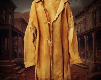 May include: A tan leather coat with fringe on the sleeves and hem, hanging on a wooden hanger. The coat has a notched collar and is fastened with leather ties. The background depicts a western town.