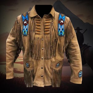 Puede incluir: Chaqueta de ante marrón con flecos y abalorios decorativos. La chaqueta tiene cuello, cierre de botones y bolsillos. Los hombros están adornados con diseños de cuentas azules y blancas con un águila. La chaqueta tiene una estética occidental o nativa americana.