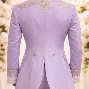 May include: A light purple suit jacket with gold embroidery on the back and cuffs. The jacket has a long, tailored design with gold buttons and a split tail. The cuffs feature white lace detailing.