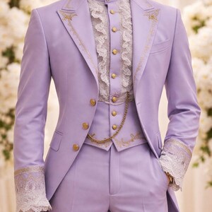 May include: A lavender three-piece suit with gold embroidery and buttons. The suit includes a jacket, vest, and trousers. The white shirt has a high collar and ruffled front. The cuffs of the jacket and the vest are adorned with gold embroidery and lace.