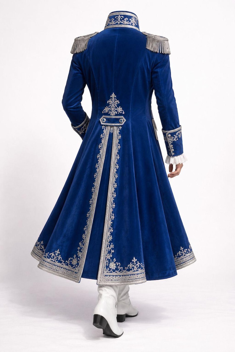 Peut inclure: Manteau en velours bleu roi avec broderies argent&eacute;es et &eacute;paulettes &agrave; franges. Le long manteau pr&eacute;sente des d&eacute;tails orn&eacute;s sur le col, les poignets et le dos, avec une jupe &eacute;vas&eacute;e. Des bottes blanches compl&egrave;tent le look.