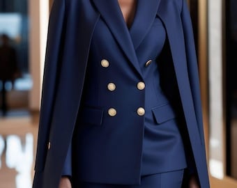May include: A navy blue suit with a double-breasted blazer and matching skirt. The blazer features gold buttons and a cape-like design. The outfit is tailored and professional, suitable for business or formal occasions.