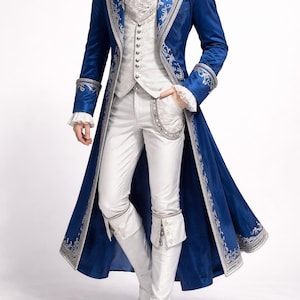 Peut inclure: Un ensemble de costume bleu et argent&eacute;. La tenue comprend un long manteau avec des bordures argent&eacute;es, un gilet blanc, un pantalon assorti et des bottes blanches. Le manteau pr&eacute;sente des &eacute;paulettes et des d&eacute;tails orn&eacute;s, cr&eacute;ant une esth&eacute;tique historique ou th&eacute;&acirc;trale.