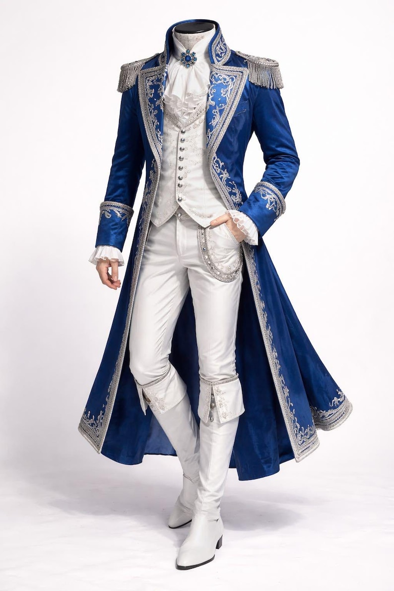 Peut inclure: Un ensemble de costume bleu et argent&eacute;. La tenue comprend un long manteau avec des bordures argent&eacute;es, un gilet blanc, un pantalon assorti et des bottes blanches. Le manteau pr&eacute;sente des &eacute;paulettes et des d&eacute;tails orn&eacute;s, cr&eacute;ant une esth&eacute;tique historique ou th&eacute;&acirc;trale.