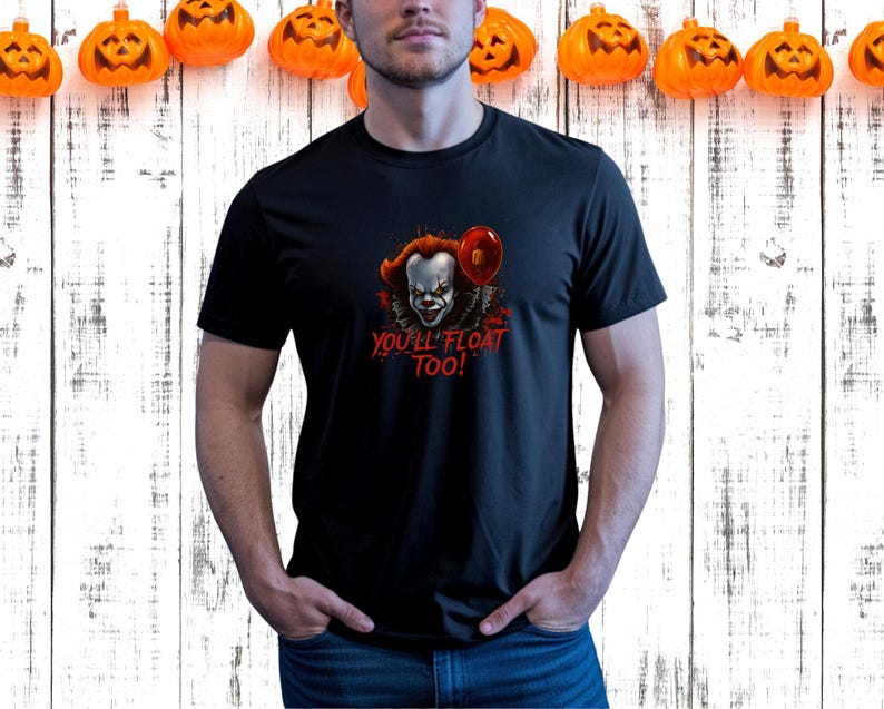 May include: Black t-shirt featuring a graphic of a scary clown with red hair and a red balloon. The text "YOU'LL FLOAT TOO!" is printed in red. The shirt is perfect for Halloween.