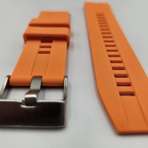 Bright orange silicone watch strap with stainless steel buckle and quick release spring bars, durable and sporty unisex replacement band.