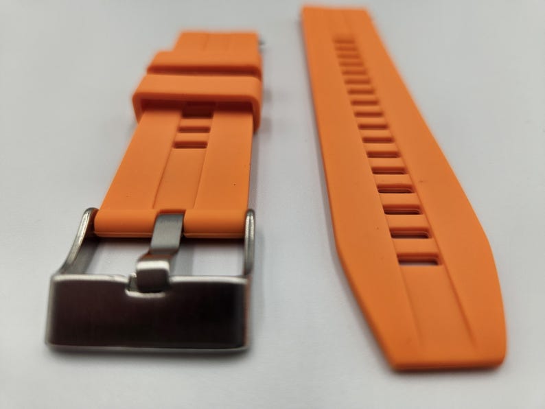 Bright orange silicone watch strap with stainless steel buckle and quick release spring bars, durable and sporty unisex replacement band.