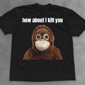 May include: Black t-shirt featuring a brown orangutan graphic with large eyes and a white mouth. The text "how about i kill you" is printed above the orangutan in white letters. The shirt is made of a soft material.