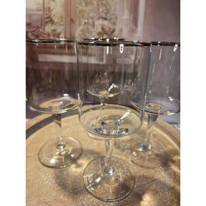 May include: A set of three ceramic mugs with a speckled, matte finish. The mugs are in shades of cream, light gray, and dark gray. Each mug has a simple, minimalist design, perfect for coffee or tea.