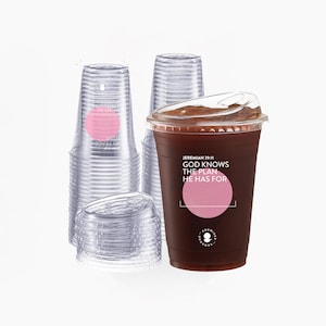 May include: Clear plastic iced coffee cups with lids, stacked and filled with a dark beverage. One cup has the text "GOD KNOWS THE PLAN HE HAS FOR" and a pink circle. The cups are from Promised Grounds.