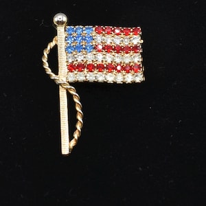 Pin PATRIÓTICO con diamantes de imitación de los años 70. Broche con la bandera estadounidense en rojo, blanco y azul, bandera ondeante.