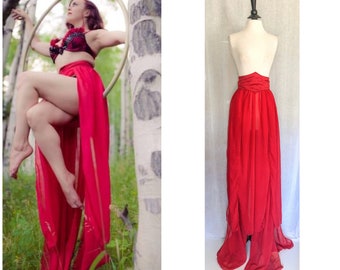 May include: A long, flowing red chiffon skirt with a gathered waistband. The skirt is layered and has a slight train.
