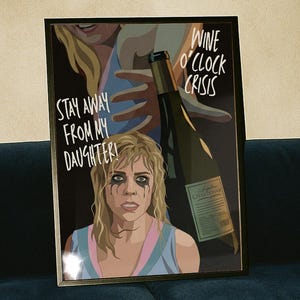 May include: Framed art print featuring a woman with dark eye makeup and the text "Stay Away From My Daughter!" and "Wine O'Clock Crisis." The print includes a wine bottle illustration. A clear champagne flute sits on a wooden table.