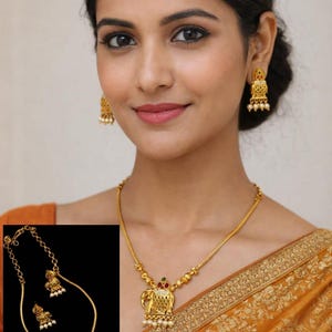 May include: Gold-toned brass jewellery set featuring a necklace and earrings. The necklace has an elephant pendant with red and green accents and small white pearls. The earrings have a similar design. The image also includes the text: No.5917-275 Matte Finish Premium Quality Made in Brass.
