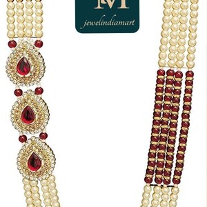 May include: A multi-strand necklace featuring faux pearls, red gemstones, and gold-toned accents. The necklace includes three ornate pendants with teardrop-shaped red stones. The logo "jewelindiamart" is visible.